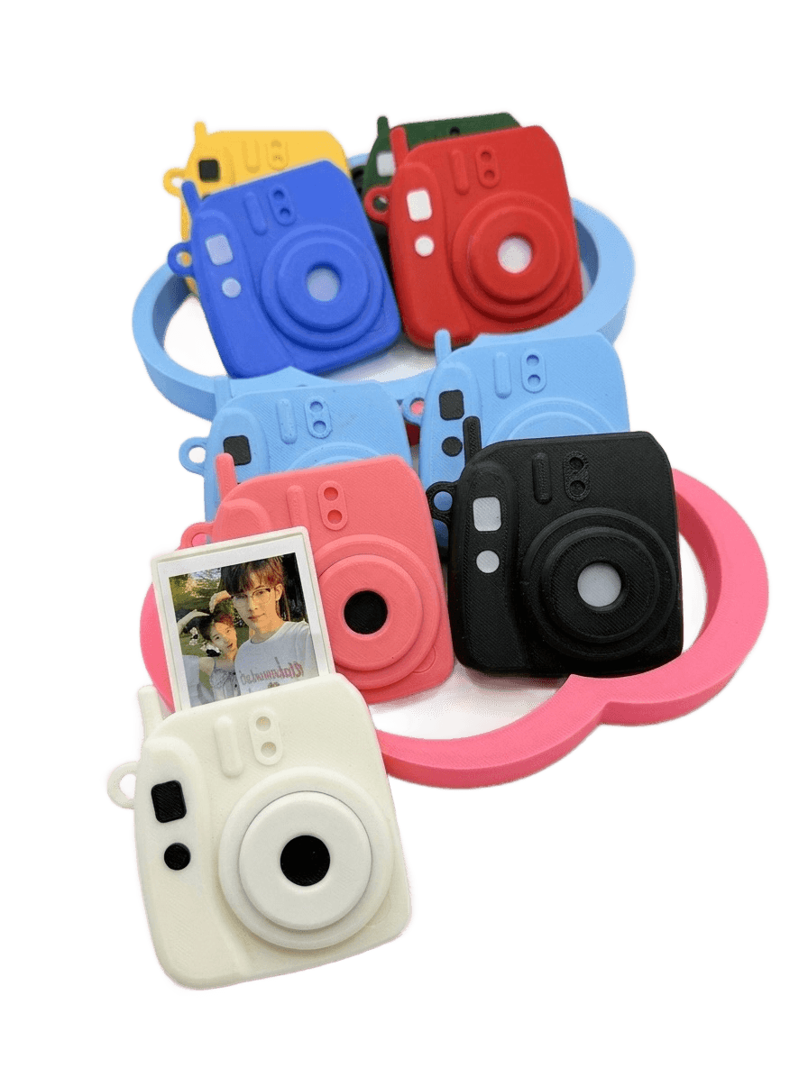 A mini camera charm on a cloud display stand